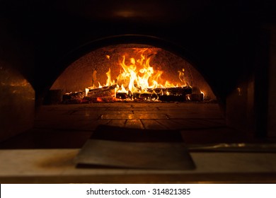 Image of a brick pizza oven with fire