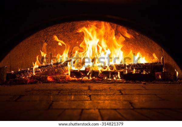 Image of a brick pizza\
oven with fire