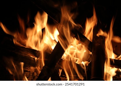 Image of burning embers in fire with charred pieces of wood