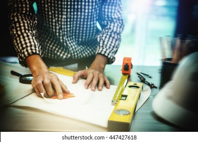 Image of business engineering planning to draw a building blueprint in his architecture project to use as job working construction standards, front view photography with vintage motion picture style.
