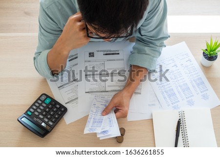 Image of a business man with financial concerns. Think hard about paying off credit card debt, house rent, and family expenses. Financial problem concept