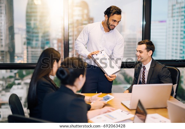 Image of business partners advice\
present discussing documents and ideas at meeting Group of business\
people sharing their ideas.smile and happy\
businessman