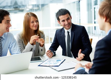 Image of business partners discussing documents and ideas at meeting - Shutterstock ID 125338145