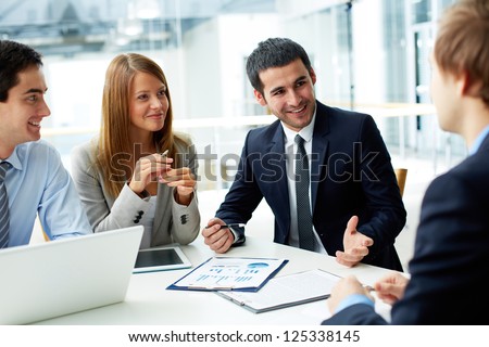 Photo of Image of business partners discussing documents and ideas at meeting