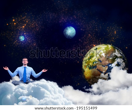 image of a businessman meditating in the clouds in space. Elements of this image furnished by NASA
