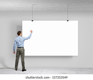 Image of businessman standing with back and writing on blank banner - Powered by Shutterstock