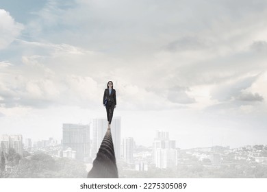 Image of businesswoman balancing on rope. Risk concept - Powered by Shutterstock