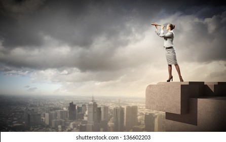 Image of businesswoman looking in telescope standing a top of building