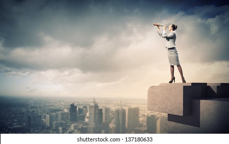 Image of businesswoman looking in telescope standing a top of building
