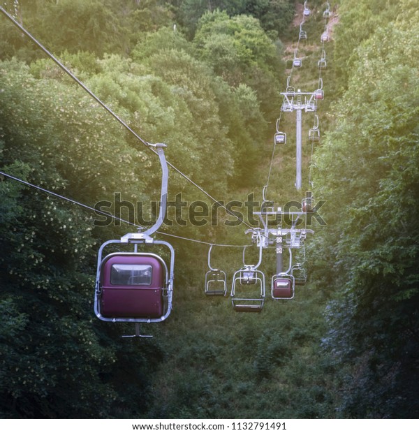 image of a cable car in the\
mountains running through a forest glade up in a beautiful\
light