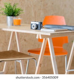 Image of camera lying on modern wooden table in studio