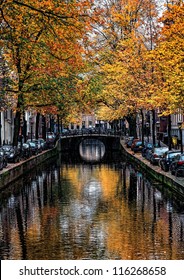 Image Of A Canal In Amsterdam With Beautiful Fall Trees Water Reflections.