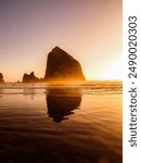 The image captures the breathtaking scenery of Haystack Rock, a iconic offshore monolith located just off the coast of Cannon Beach, Oregon.