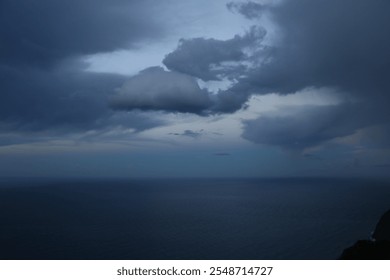 The image captures a dramatic and contrasting moment in the sky. Dark, dense clouds, heavy with rain, dominate most of the scene, creating a gloomy and stormy atmosphere. However, a beam of light filt