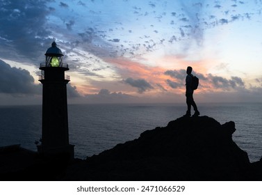 The image captures the spirit of exploration and yearning for new beginnings. The lone figure gazes out at the horizon, the rising sun casts a warm glow, symbolizing the potential for a bright future. - Powered by Shutterstock