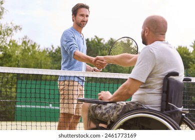 An image capturing a warm moment of sportsmanship as a man using a wheelchair and his opponent shake hands over a tennis net, symbolizing inclusion and the spirit of the game. - Powered by Shutterstock