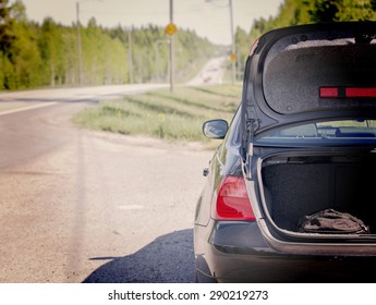 An Image Of A Car Trunk Open Waiting For Help In Side Of The Road. Image Has A Vintage Effect.