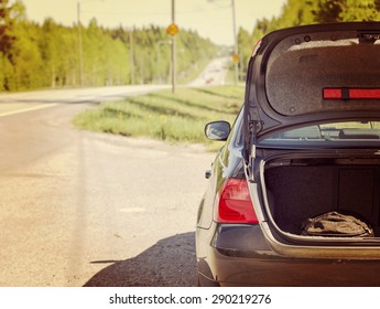 An Image Of A Car Trunk Open Waiting For Help In Side Of The Road. Image Has A Vintage Effect.