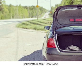 An Image Of A Car Trunk Open Waiting For Help In Side Of The Road. Image Has A Vintage Effect.