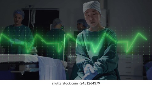 Image of cardiograph over asian female surgeon wearing medical gloves at hospital. Medicine, healthcare and digital interface concept concept digitally generated image. - Powered by Shutterstock