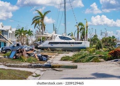 Image of a catamaran resting on a residential neighborhood street after Hurricane Ian Fort Myers FL - Shutterstock ID 2209129465