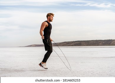 Image of caucasian athletic sportsman working out with jumping rope on nature - Powered by Shutterstock