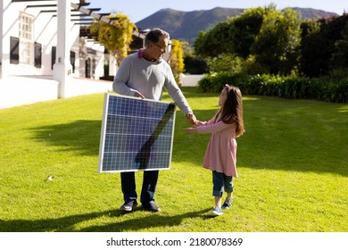 Image of caucasian grandfather with solar panel and granddaughter. Family, green energy, eco awareness and spending quality time together concept. - Powered by Shutterstock