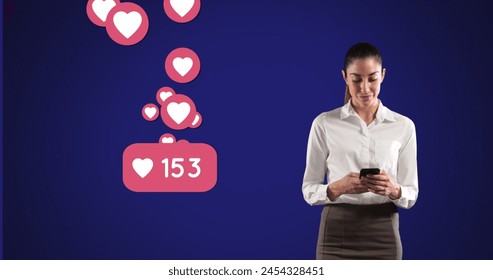 Image of Caucasian woman using smartphone over heart emojis floating on blue background. Global economy and technology concept digital composite - Powered by Shutterstock