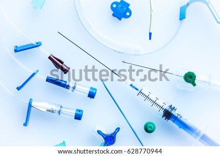 Image of central venous catheter insertion set with needle,syringe and plastic tubes on a blue background