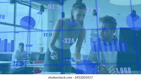 Image of changing numbers and graphs over diverse coworkers discussing reports on desk. Digital composite, multiple exposure, business, planning, growth, teamwork and technology concept.