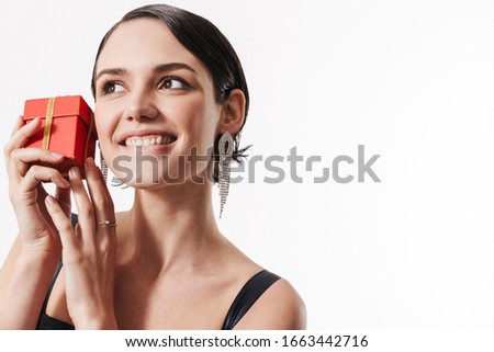 Image of charming young glamorous happy woman smiling and holding small present box isolated over white background