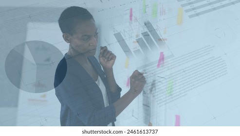 Image of charts and data processing over african american businesswoman brainstorming. business, global communication and digital interface technology concept digitally generated image.