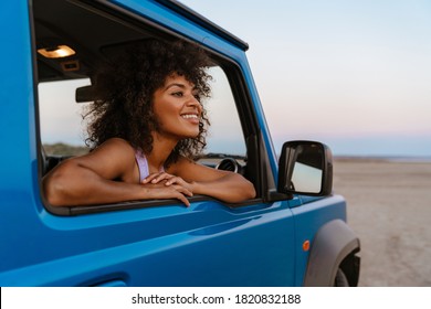 Image Of Cheerful African American Woman Smiling While Travelling In Car On Desert