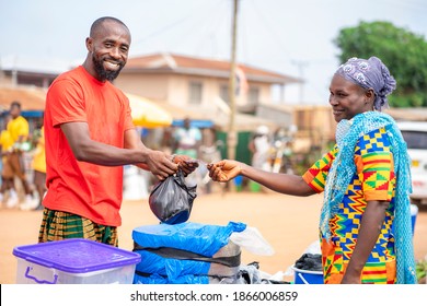 Image Of Cheerful African Guy, With Ghana Cedi Note In His Hand, Woman With Head Gear In Front- Trading Concept