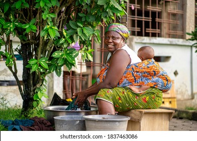 Image Of Cheerful African Woman, Baby At Her Back- Laundry Concept 