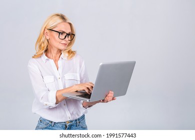 Image Of Cheerful Mature Business Woman Standing Isolated Over White Background Using Laptop Computer. Portrait Of A Smiling Senior Lady Holding Laptop Computer.