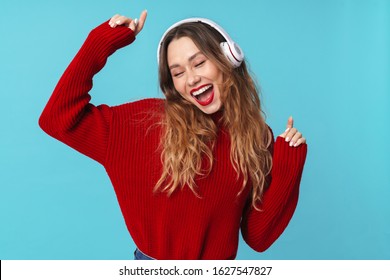 Image of cheerful pretty woman using headphones and dancing isolated over blue background - Shutterstock ID 1627547827