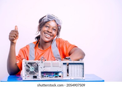 image of cheerful young african lady, with protective eye glass and thumb up sign, sitting in front of system unit- hardware technician concept - Shutterstock ID 2054907509