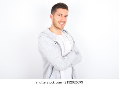 Image of cheerful young caucasian man wearing casual clothes over white background with arms crossed. Looking and smiling at the camera. Confidence concept.