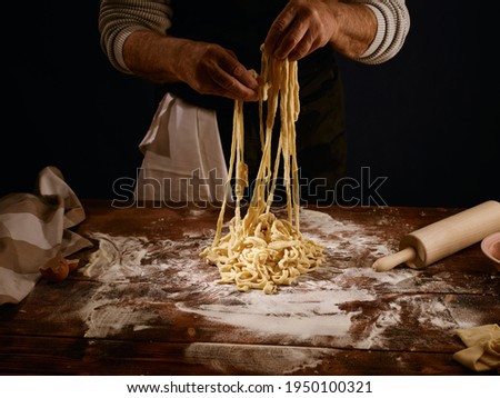 Image of a chef pulling the freshly made pasta