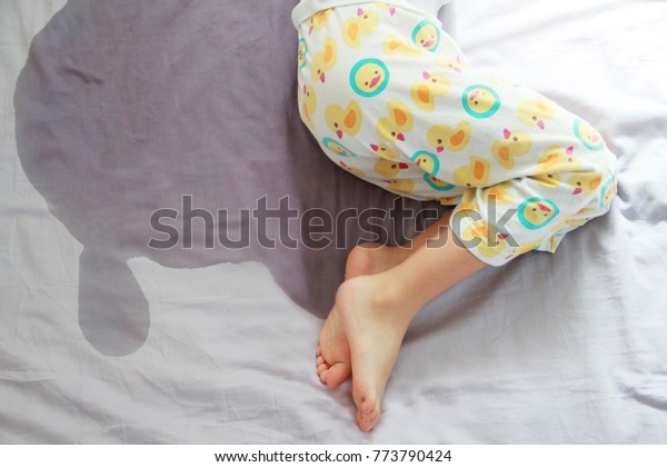 Image of child pee on the\
mattress.The picture of bed-wetting situation in 4 or 5 years old\
girl.Girl wet the bed while she was sleeping.Selective\
focus