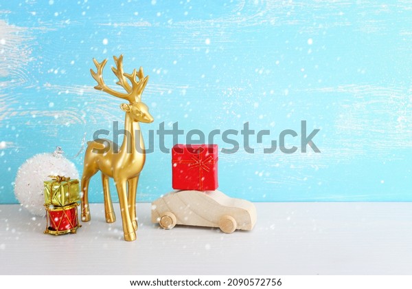 Image of christmas decorations and gold deer\
in front of pastel blue\
background