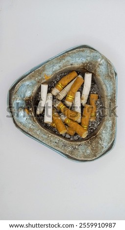 image of a cigarette butt that has been smoked with an ashtray as a place for it