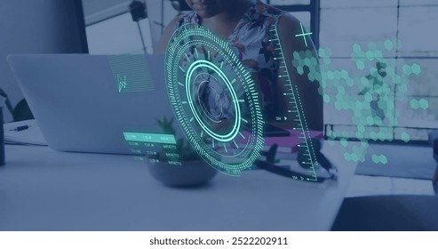 Image of circular scanner and data over african american businesswoman using laptop at office. Business, network, processing, digital interface and communication, digitally generated image.