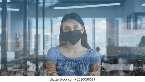 Image of cityscape over caucasian woman wearing face mask in office. global business, digital interface and technology concept during covid 19 pandemic digitally generated image. - Powered by Shutterstock