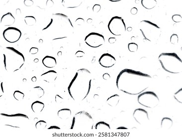 The image is a close up of raindrops on a window. The raindrops are scattered all over the window, creating a blurry and hazy effect