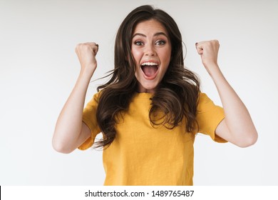 Image closeup of happy brunette woman wearing casual t-shirt screaming and clenching fists isolated over white background