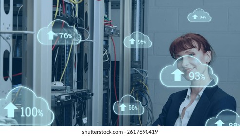 Image of cloud icons with growing numbers over caucasian woman in server room. global technology, data processing and digital interface concept digitally generated image.