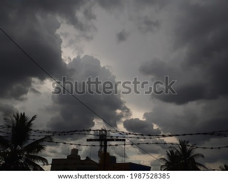  Image of clouds turning into dramatic dark storm clouds as the weather changes in a local residential area. - Climate changes due to approaching cyclone in the region. Dark clouds in the sky.