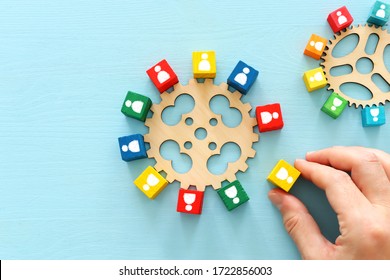imagen de bloques coloridos con íconos de personas sobre mesa de madera, recursos humanos y concepto de gestión